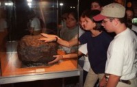 Nios tocando el Meteorito de Molina expuesto en el Museo Nacional de Ciencias Naturales