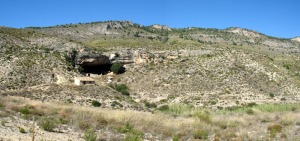 Una cueva que fue utilizada para corral de ganado. El frente de la cueva es una falla. Al fondo el anticlinal del Cejo Cortado 