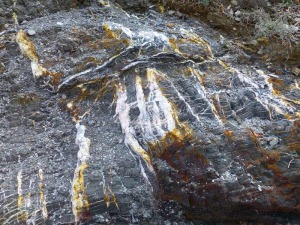 Mineralizaciones de jarosita (color amarillento), alunita (color blanco) y xidos de hierro (color rojizo) la ladera norte del Cerro del Atalayn