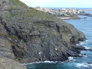 Los deslizamiento son frecuentes en los esquistos grafitosos, especialmente cuando estos buzan hacia el mar. Al fondo Cala Reona