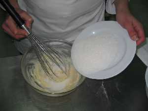 Añadir el azucar a la mezcla de manteca y huevos 